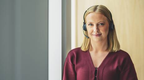 Dame med headset som smiler