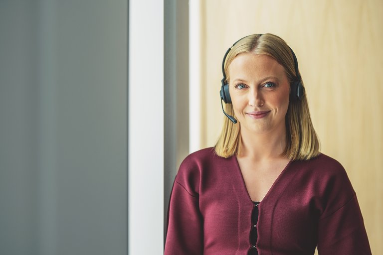 kundeveileder Ida Gangdal i KLP med headset som smiler