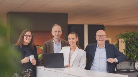 Fire smilende mennesker på et kontor