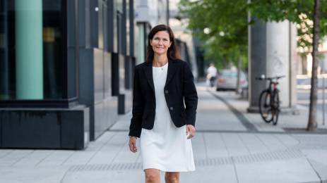 Jorunn Ygre Storjohann i kjole og blazer med bybildet i bakgrunnen