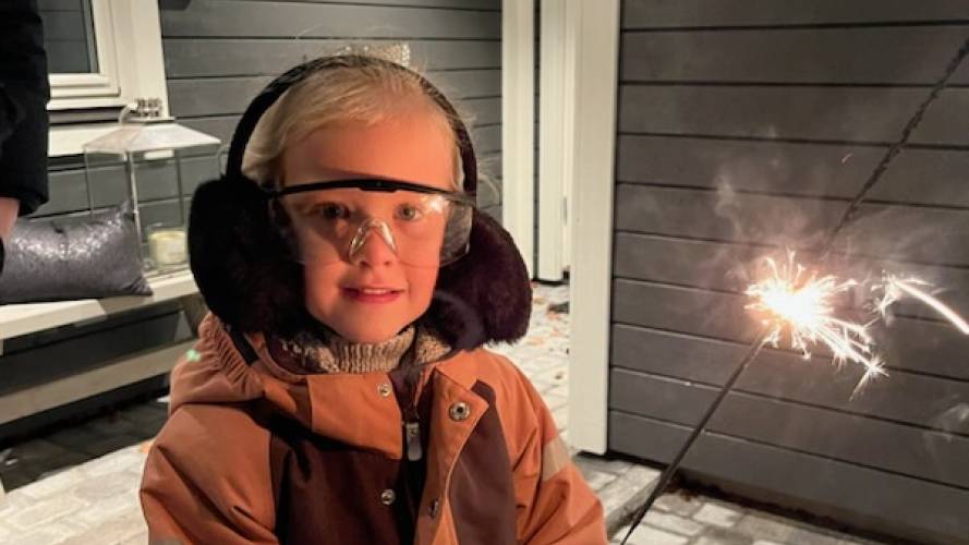 Liten jente holder stjerneskudd og har på hørselsvern.