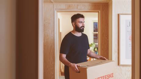 Ung mann bærer flytteske innendørs