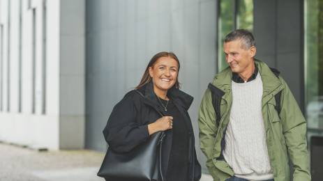 Man og dame som står utendørs og smiler