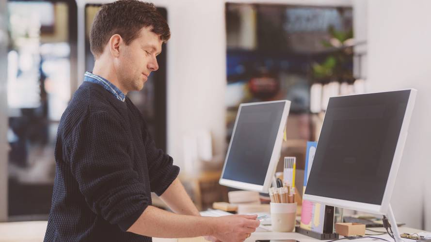 Ung mann tæpper bankkort på kortterminal i butikk