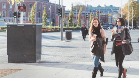 Veninner med kaffe gående i Oslo by