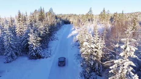 Bil på vintervei gjennom skogen