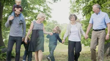 Familiebilde av tre generasjoner som holder hendene til hverandre