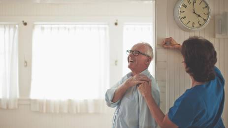 Helsearbeider/hjemmehjelp som måler en eldre blid mann