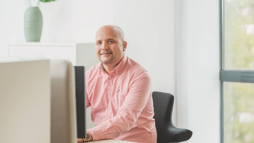 Mann som sitter ved kontorpult