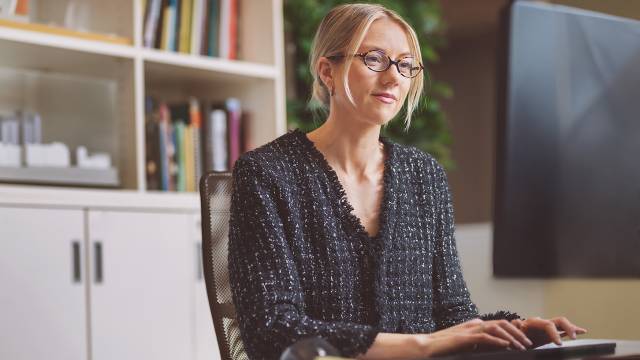 Dame med briller som jobber på pc