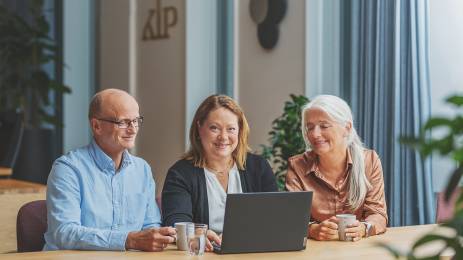 Tre personer som ser sammen på en pc