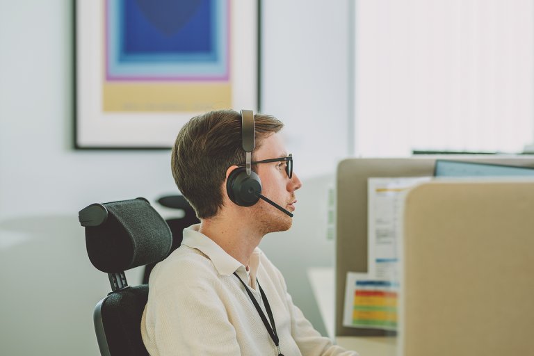 Man som sitter med headset på kundeservice